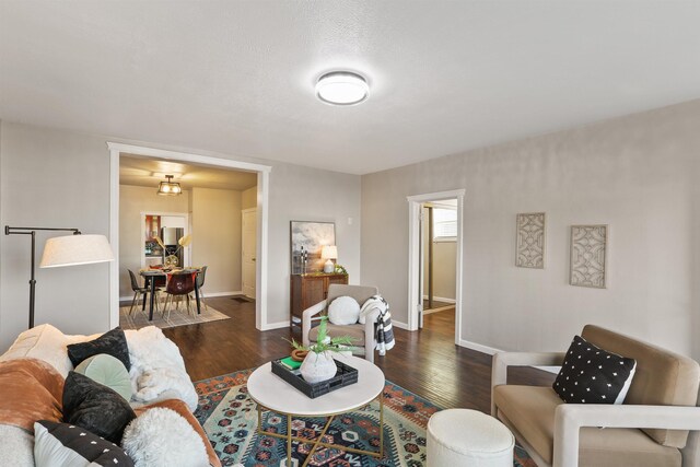 living room with a textured ceiling and dark hardwood / wood-style flooring