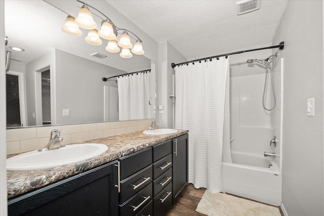 bathroom featuring shower / bath combination with curtain, wood-type flooring, vanity, a textured ceiling, and backsplash