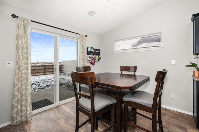 dining room with lofted ceiling and dark hardwood / wood-style flooring