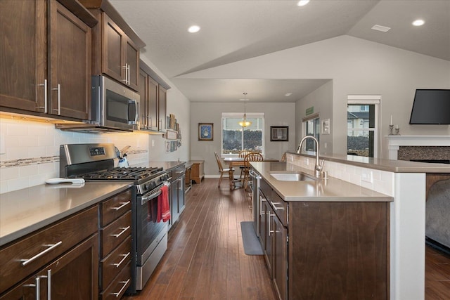 kitchen featuring sink, lofted ceiling, backsplash, and appliances with stainless steel finishes