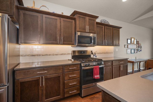 kitchen with tasteful backsplash, stainless steel appliances, dark hardwood / wood-style flooring, and dark brown cabinetry