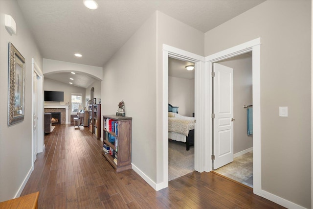 hall with dark wood-type flooring and vaulted ceiling