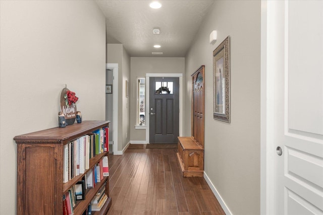 entrance foyer with dark wood-type flooring and a textured ceiling