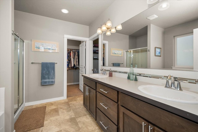 bathroom featuring an enclosed shower, a textured ceiling, and vanity