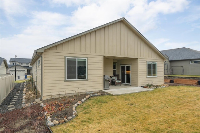 rear view of property featuring a patio and a yard