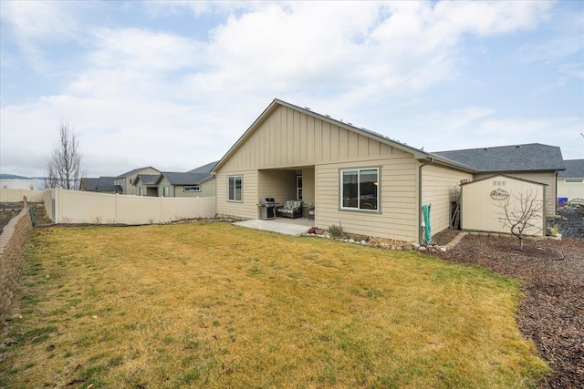 rear view of property featuring a yard, a storage shed, and a patio