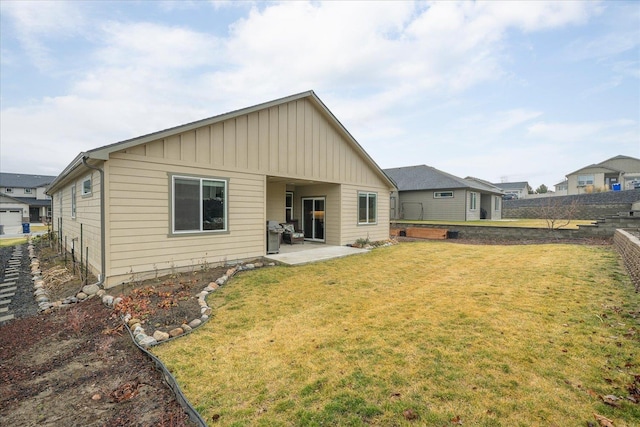 rear view of house featuring a patio area and a yard