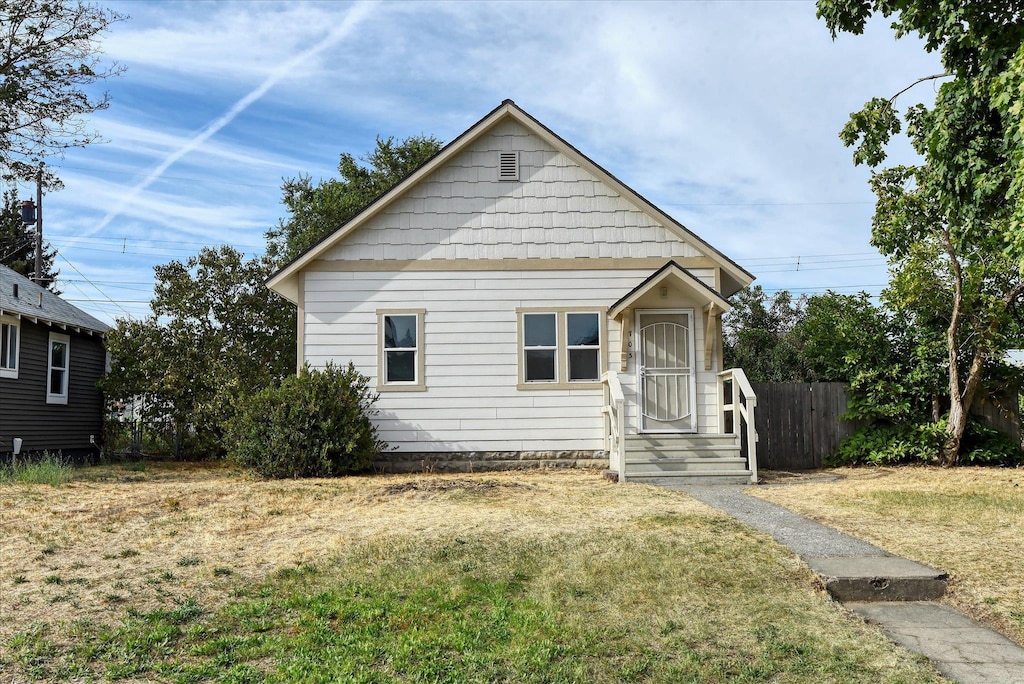 bungalow-style home featuring a front lawn