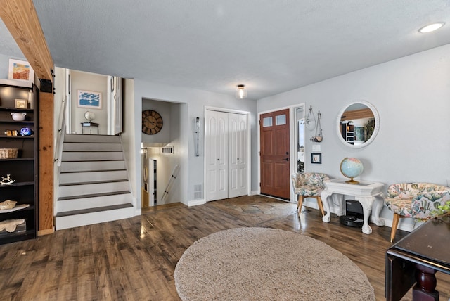 foyer featuring dark hardwood / wood-style flooring and a textured ceiling