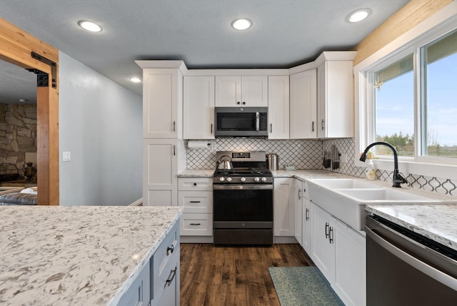 kitchen featuring white cabinets, stainless steel appliances, dark hardwood / wood-style flooring, and sink