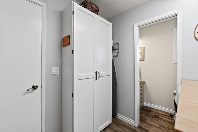 hallway featuring a textured ceiling and dark hardwood / wood-style floors