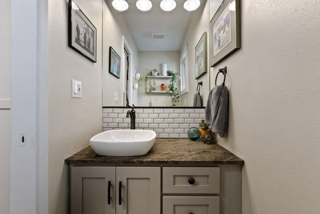 bathroom featuring vanity and tasteful backsplash