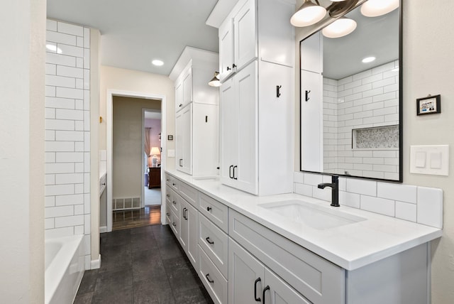 bathroom featuring tiled shower / bath combo and vanity