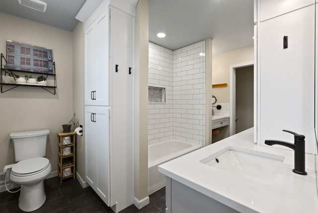 full bathroom featuring toilet, vanity, and tiled shower / bath combo