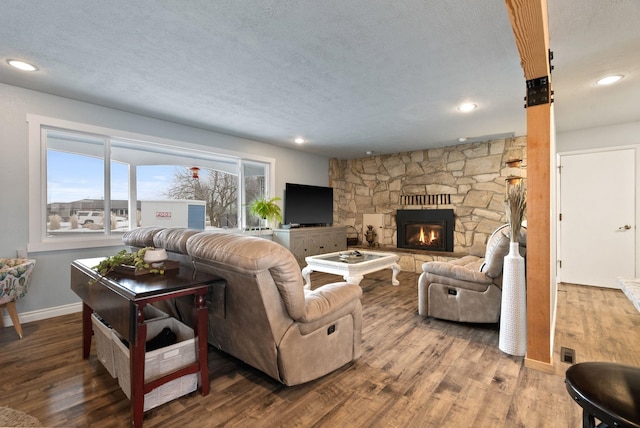 living room featuring a textured ceiling, a fireplace, and hardwood / wood-style flooring