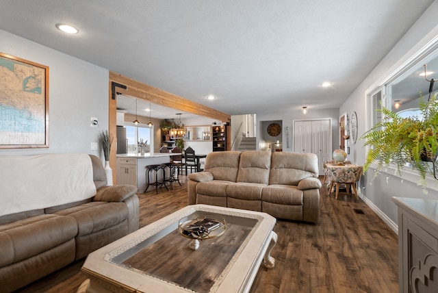 living room featuring beamed ceiling and dark hardwood / wood-style floors