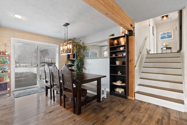 dining room with dark hardwood / wood-style flooring, an inviting chandelier, and a textured ceiling