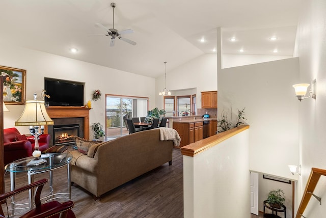 living room with dark hardwood / wood-style floors, high vaulted ceiling, and ceiling fan with notable chandelier