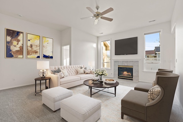 carpeted living room with a tile fireplace, ceiling fan, and a wealth of natural light