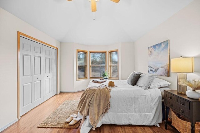 bedroom featuring ceiling fan, hardwood / wood-style floors, ensuite bathroom, and vaulted ceiling