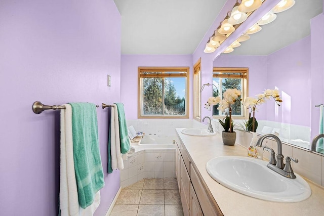 bathroom featuring tile patterned flooring, tiled bath, and vanity