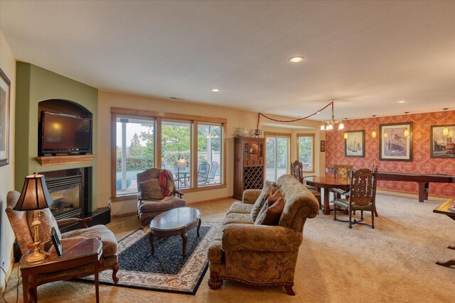 dining room with a fireplace, a notable chandelier, and light colored carpet