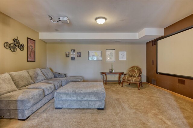 carpeted home theater with an inviting chandelier