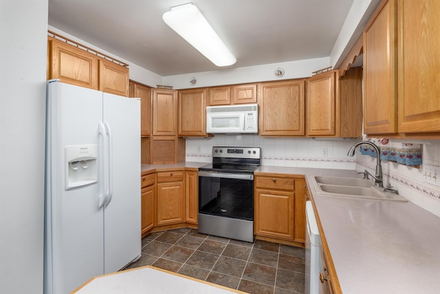 kitchen with sink, white appliances, and tasteful backsplash