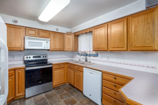 kitchen featuring white appliances, tasteful backsplash, and sink