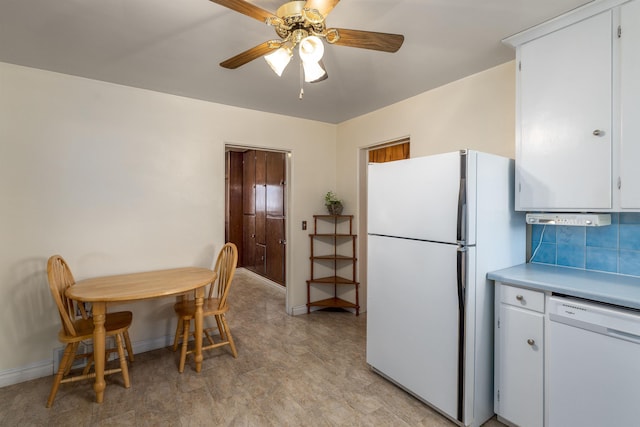 kitchen with white appliances, ceiling fan, backsplash, and white cabinets