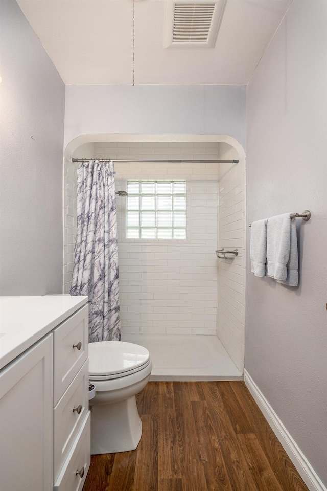 bathroom with toilet, wood-type flooring, walk in shower, and vanity