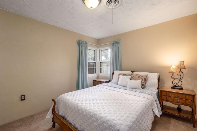 bedroom with carpet floors and a textured ceiling