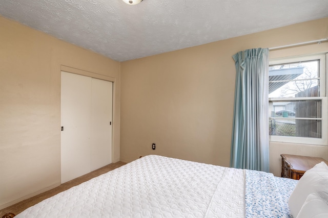 bedroom with carpet flooring, a closet, and a textured ceiling