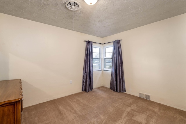 carpeted spare room with a textured ceiling