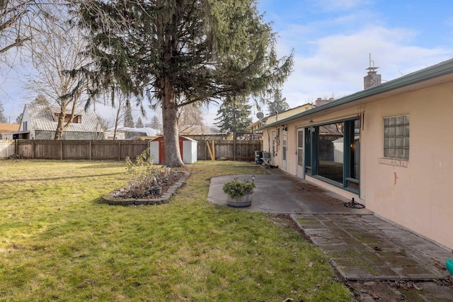 view of yard featuring cooling unit, a shed, and a patio area