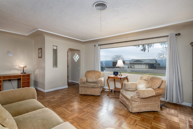 living room featuring a textured ceiling, parquet flooring, and plenty of natural light