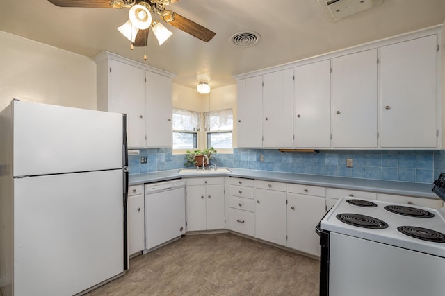 kitchen featuring sink, white appliances, white cabinetry, and backsplash