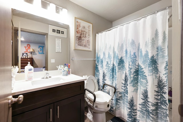 bathroom featuring toilet, vanity, and walk in shower