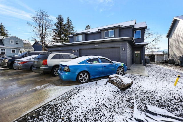 front of property featuring central AC and a garage