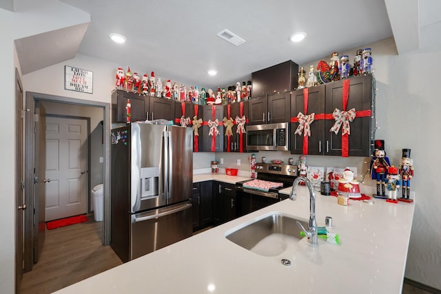 kitchen with stainless steel appliances, wood-type flooring, sink, and kitchen peninsula