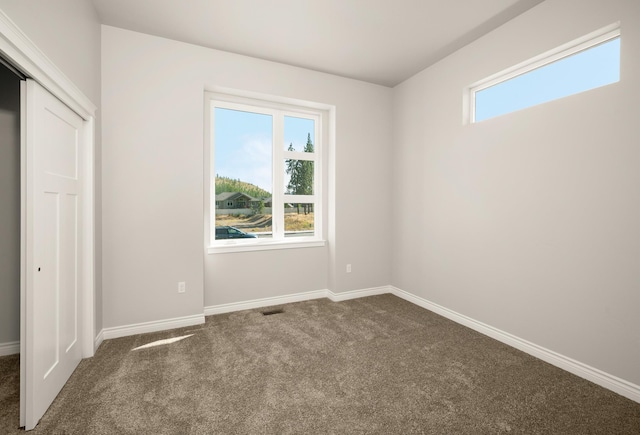 spare room with dark carpet