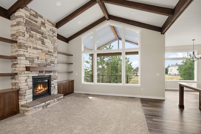 unfurnished living room with hardwood / wood-style flooring, an inviting chandelier, vaulted ceiling with beams, and a stone fireplace