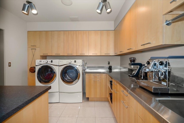 clothes washing area featuring cabinets, separate washer and dryer, and light tile patterned floors