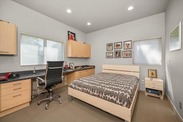 bedroom with built in desk and carpet