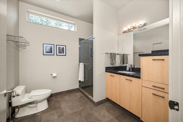 bathroom featuring toilet, a shower with shower door, and vanity