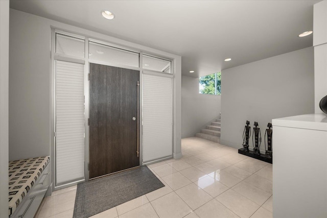 entrance foyer with washer / dryer and light tile patterned flooring