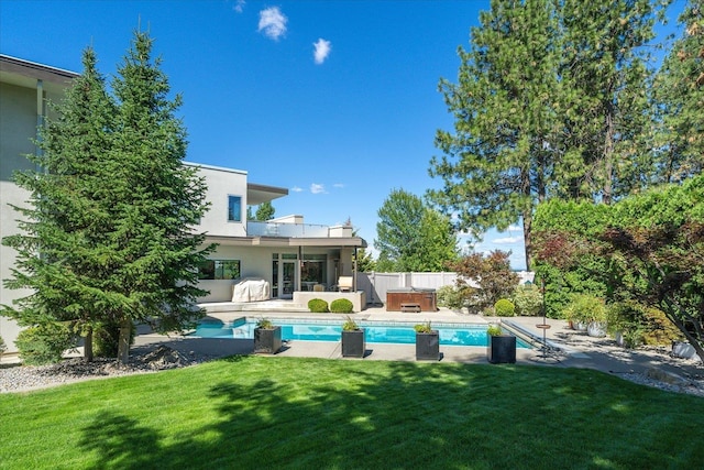 view of swimming pool with a hot tub, a patio, and a lawn