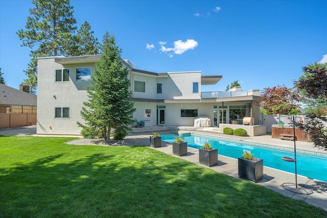 back of property with a lawn and a patio area