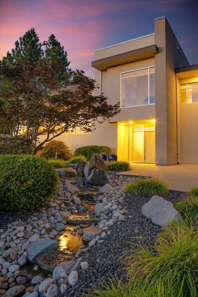 property exterior at dusk with a patio