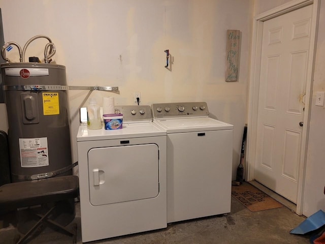 clothes washing area with washer and dryer and strapped water heater